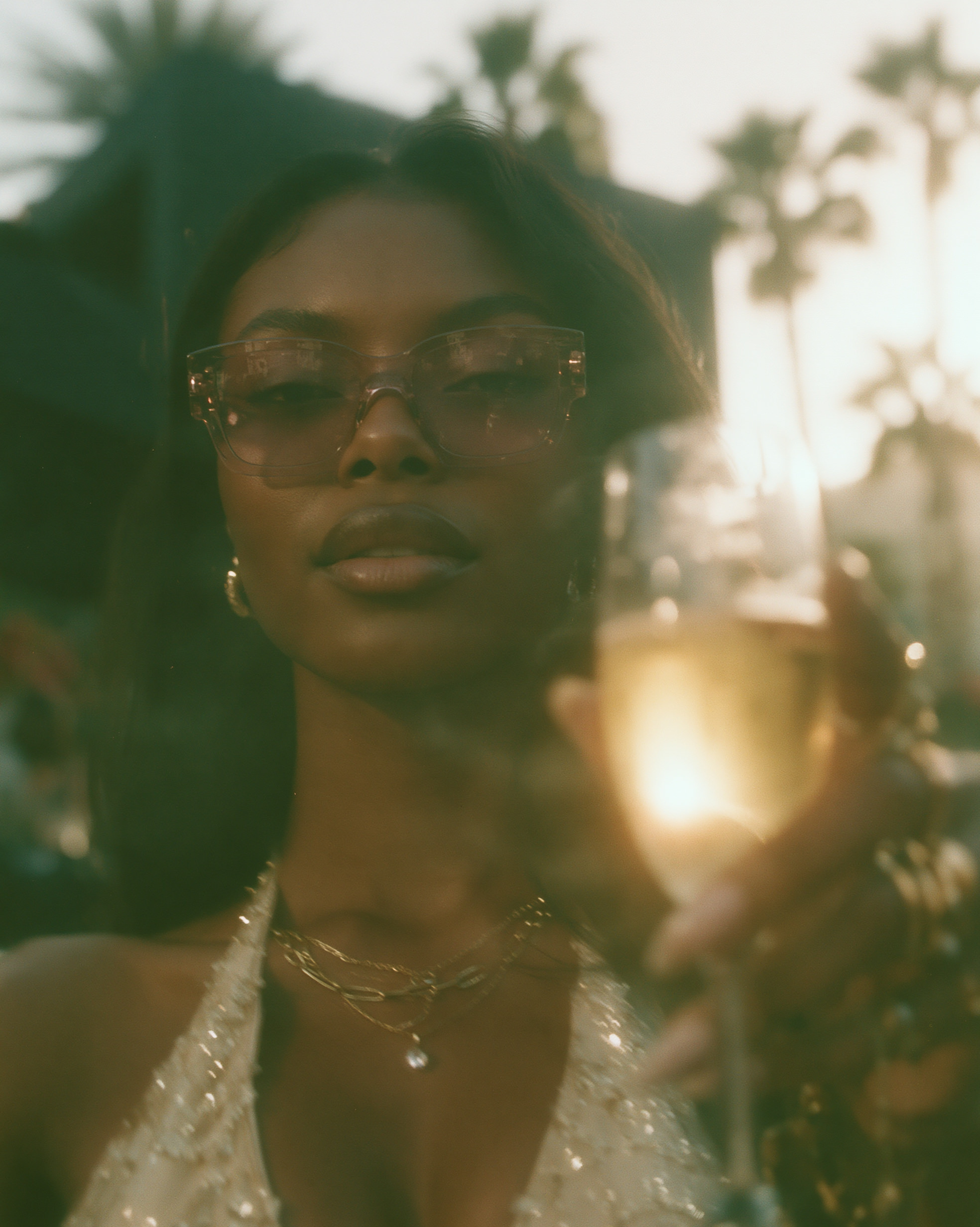 Golden-hour portrait with champagne glass, lens flare